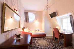 a hotel room with a bed and a table and a mirror at Hotel Haus Müller in Marburg an der Lahn
