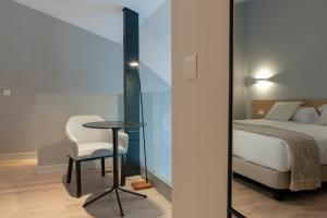 een slaapkamer met een bed, een tafel en een stoel bij MH Apartments Central Madrid in Madrid