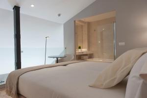 a bedroom with a large white bed and a window at MH Apartments Central Madrid in Madrid