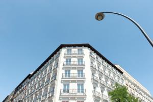 un edificio blanco alto con luz de la calle en MH Apartments Central Madrid, en Madrid