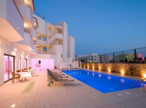 una piscina sul lato di un edificio con luci di My Way Luxury Ibiza Studio - AB Group a Playa d'en Bossa