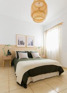 una camera con un grande letto e un lampadario a braccio di Apartamento Good Morning Velvet a Vecindario