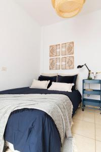 una camera con letto e lenzuola bianche e blu di Apartamento Good Morning Velvet a Vecindario