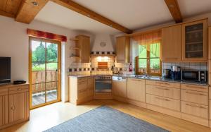 a large kitchen with wooden cabinets and a large window at Unterschwabegghof in Werfen