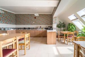a kitchen and dining room with wooden tables and chairs at Silver Hotel Budapest City Center in Budapest