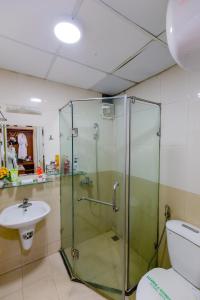 a bathroom with a glass shower and a sink at A25 Hotel - 46 Châu Long in Hanoi