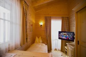 キュータイにあるAlpenchalets - Obholzerのテレビ付きのベッドが備わる小さな客室です。