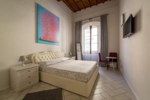 um quarto com uma cama, uma mesa e uma janela em duallook em Florença