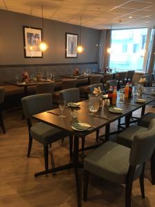 a dining room with tables and chairs in a restaurant at Finnsnes Hotel in Finnsnes