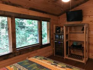 een slaapkamer met een bed en een televisie in een hut bij Art Loft in Sevierville