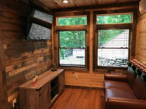 una sala de estar en una cabaña de madera con ventanas en Art Loft, en Sevierville