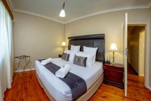 a bedroom with a large bed with white sheets and pillows at Munro Suites in Port Elizabeth