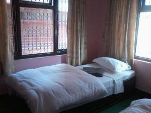 a bedroom with two beds and a window at Bardia Jungle Cottage in Bardiyā