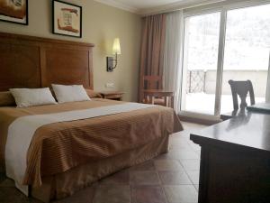 um quarto de hotel com uma cama e uma grande janela em Hotel Pamplona Villava em Villava