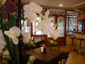un grupo de flores blancas sentadas sobre mesas en un restaurante en Hotel Fin De Semana, en Gandía