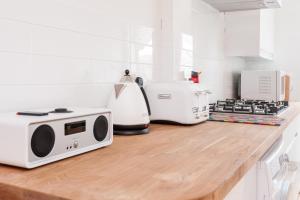 un comptoir de cuisine avec un micro-ondes et des appareils électroménagers dessus dans l'établissement Sea Breeze Cottage with Parking by MyHolidayLet, à Brighton et Hove