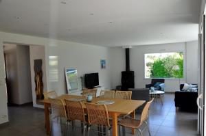 een eetkamer en woonkamer met een tafel en stoelen bij Maison Roche Blanche in Port Blanc