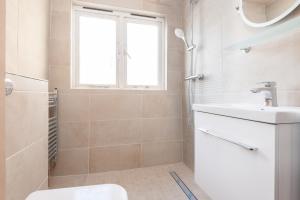 une salle de bain avec un lavabo et des toilettes et une fenêtre dans l'établissement Sea Breeze Cottage with Parking by MyHolidayLet, à Brighton et Hove