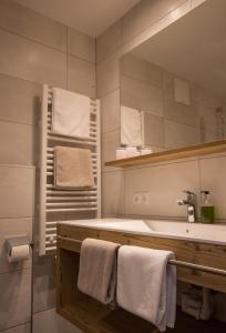een badkamer met een wastafel, een spiegel en handdoeken bij Haus Sattelblick in Sankt Anton am Arlberg