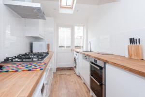une cuisine avec des murs blancs et une cuisinière four supérieur dans l'établissement Sea Breeze Cottage with Parking by MyHolidayLet, à Brighton et Hove 6 autres photos