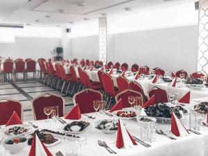 a conference room with tables and red chairs and food at Baltazaras in Vilnius +41 photos