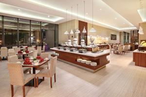 uma sala de jantar com mesas e cadeiras e um restaurante em Swiss-Belhotel Sorong em Sorong