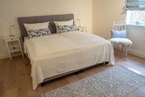 a bedroom with a large bed and a chair at Hygge Hus in Westerland