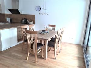a dining room table with chairs and a kitchen at Ferienwohnung Enzblick in Bad Wildbad