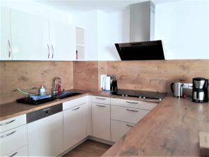 a kitchen with white cabinets and a wooden counter top at Ferienwohnung Enzblick in Bad Wildbad