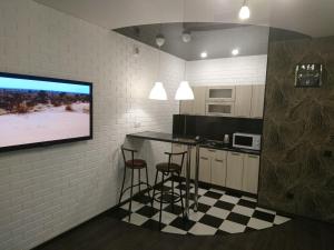 a kitchen with a bar and a tv on a wall at Studio Loft in Saransk