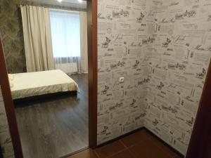 a room with a bed and a wall covered in papers at Studio Loft in Saransk