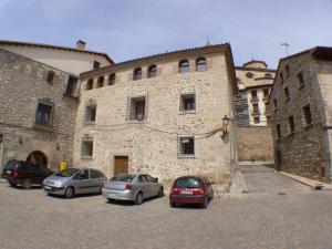 a group of cars parked in front of a stone building at 1g CASA DE LOS FERNANDEZ RAJO in Orihuela del Tremedal