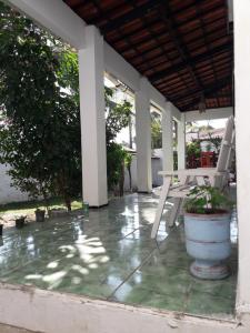 a porch with chairs and a table and trees at Paracuru HolaOnda Wavehospedajem in Paracuru