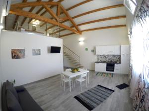 a living room with a white table and a kitchen at Sirio in Birgi Vecchi