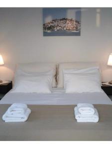 a white bed with two folded towels on it at Sea view house on Poros in Poros