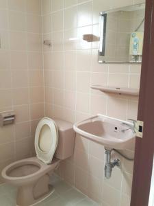 a bathroom with a toilet and a sink at Sathitsit Mansion in Bangkok