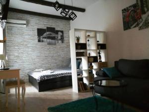 Saramala Apartment في بلغراد: غرفة معيشة مع أريكة وجدار من الطوب
