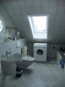 a bathroom with a toilet sink and a washing machine at Ferienwohnung Max-und-Moritz in Flensburg