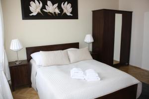 a bedroom with a bed with two towels on it at Place 4 You Apartments in Krakow