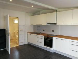 a kitchen with white cabinets and a sink at Finnenhaus in Neumünster