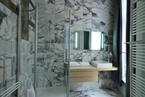y baño con ducha acristalada y lavamanos. en Hotel Retro en Bruselas