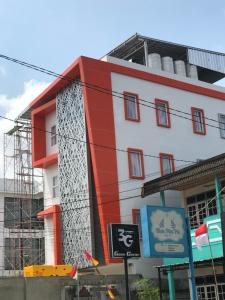 een rood-wit gebouw met steigers eromheen bij Cemerlang Inn in Palembang