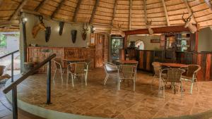 un comedor con mesas y sillas en una casa en Boulders Safari Lodge, en Malelane