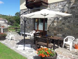 un patio con sombrilla, mesa y sillas en Terrazze sul frido en Viggianello
