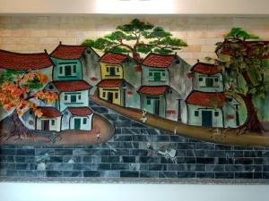 una pintura de un grupo de casas en una pared en Anova Airport Hotel, en Noi Bai