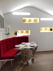 un canapé rouge et une table dans une pièce dans l'établissement Tetti Rossi, à Bologne