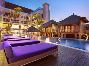 rząd fioletowych szezlonków przy basenie w obiekcie Grand Mega Resort & Spa Bali w mieście Kuta