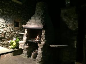 Un horno de ladrillo de piedra con fuego. en Casa Ramón La Caseta, en Sin