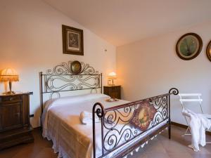 Schlafzimmer mit einem Bett mit einem schmiedeeisernen Kopfteil in der Unterkunft Belvilla by OYO Giardino delle Giare in Castiglion Fiorentino