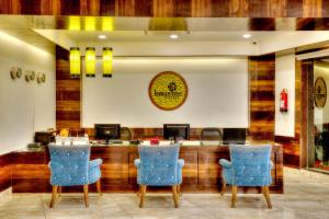 een restaurant met blauwe stoelen en een bar bij Lemon Tree Hotel, Katra in Katra